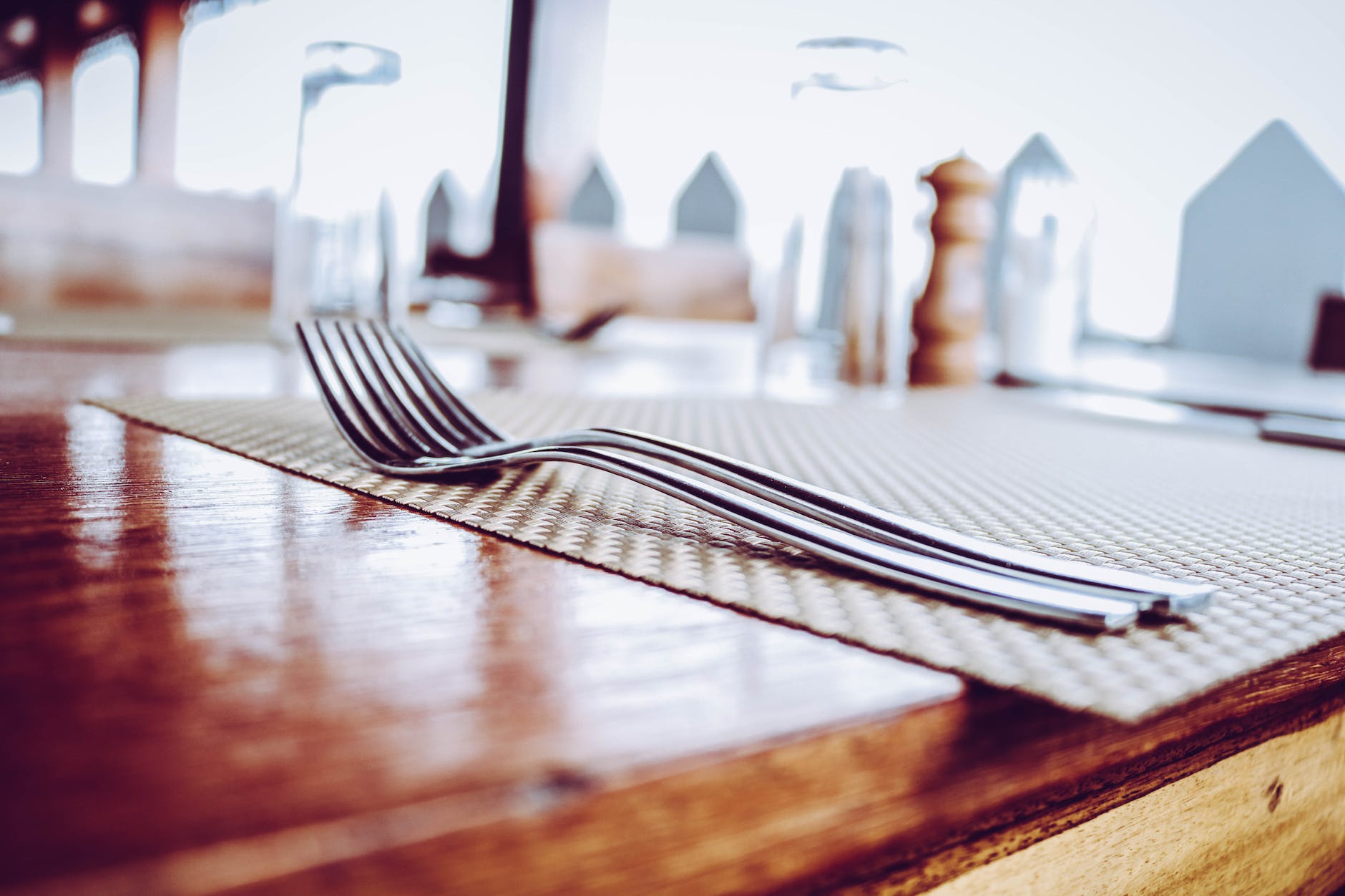 two stainless steel forks on top of place mat