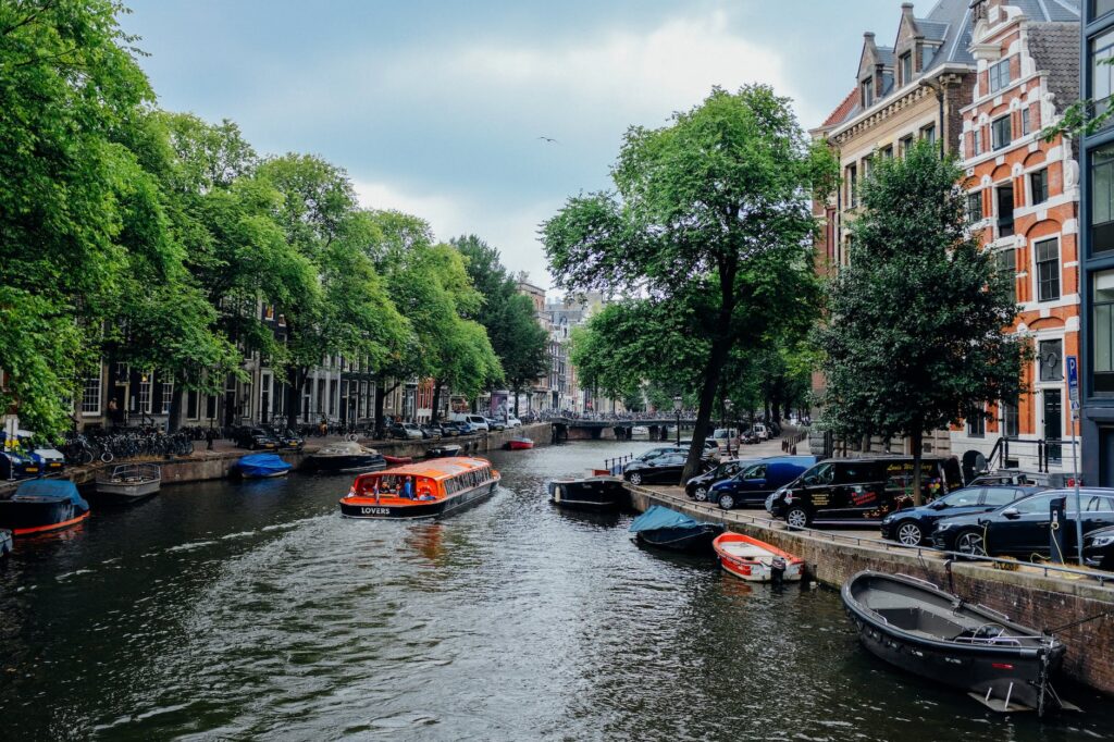 picturesque canal with floating boats in old district of city with aged buildings